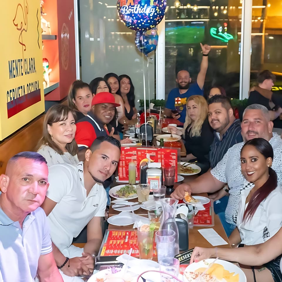 A large group of people celebrating a birthday at Whiskylucan Miami, a Mexican restaurant.